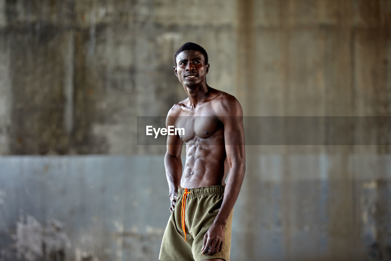 portrait of young man standing against wall