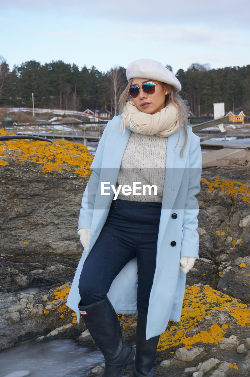 Portrait of woman wearing sunglasses while standing against sky