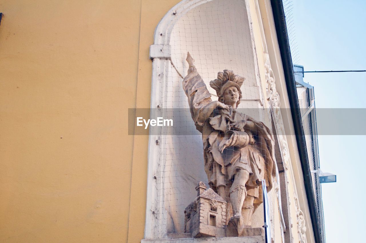 LOW ANGLE VIEW OF STATUES AGAINST BUILDING