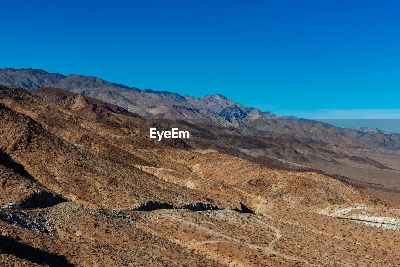 Scenic view of mountains against blue sky in death valley