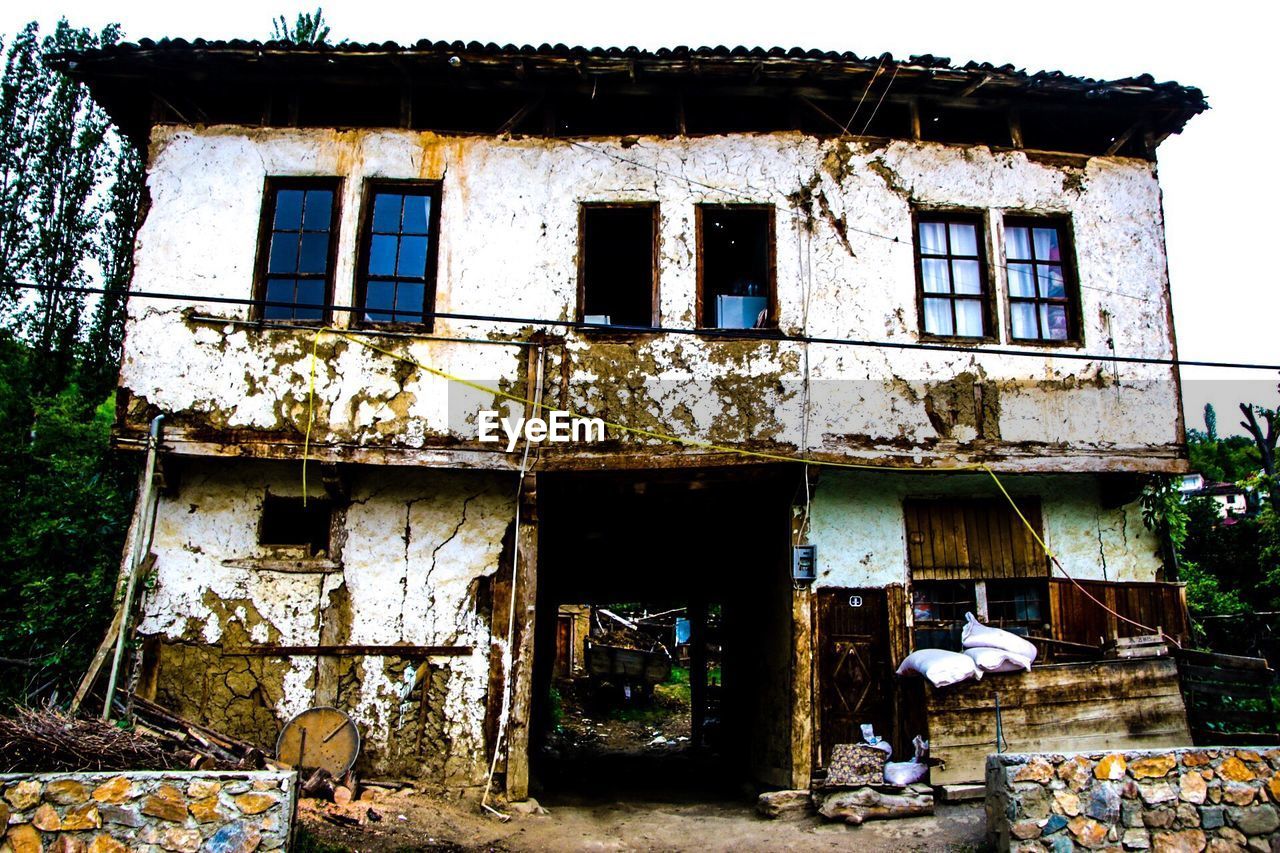 LOW ANGLE VIEW OF ABANDONED HOUSES