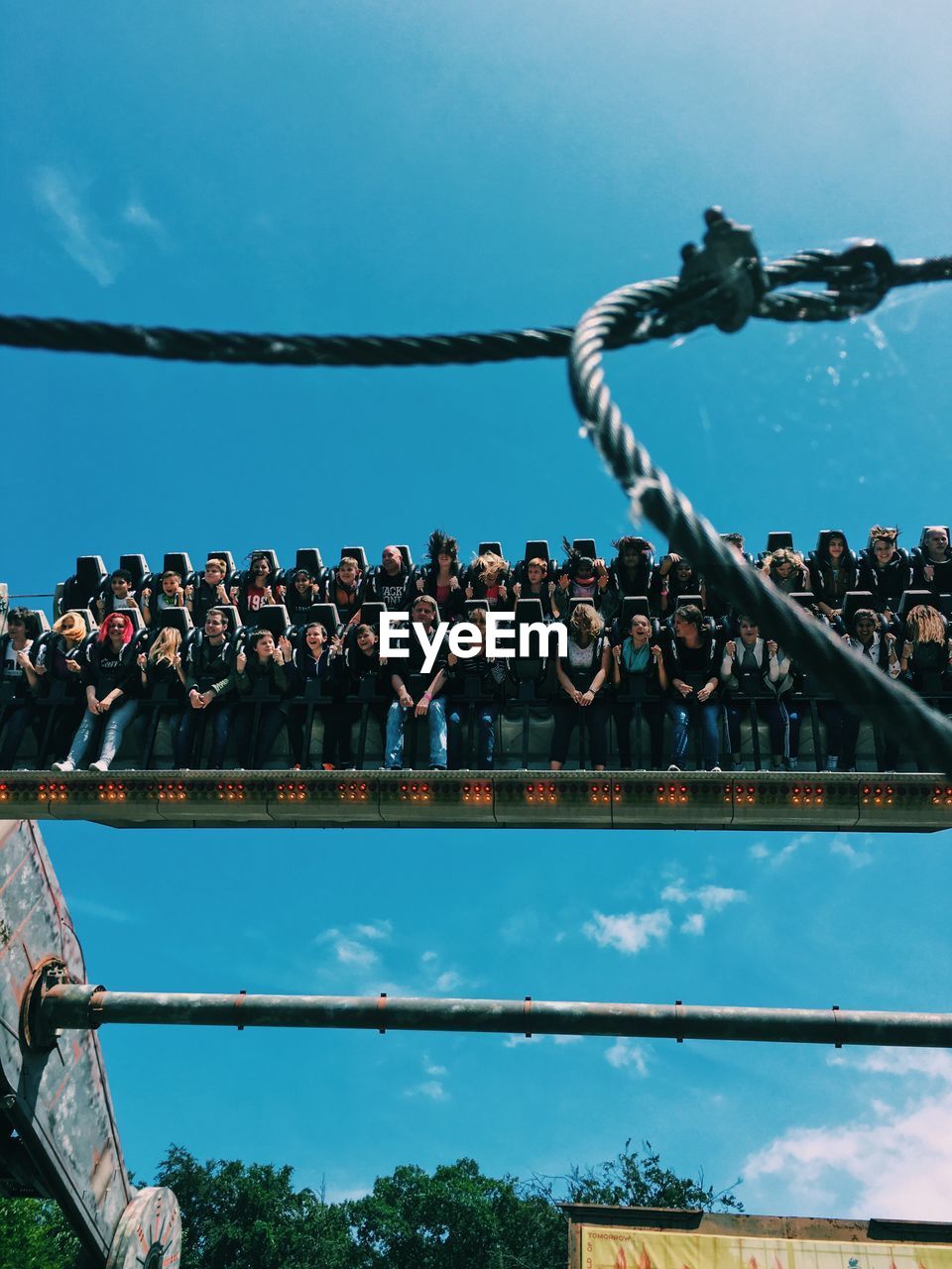 People riding on amusement park ride against sky