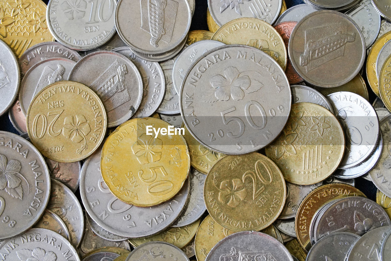 FULL FRAME SHOT OF COINS ON METAL