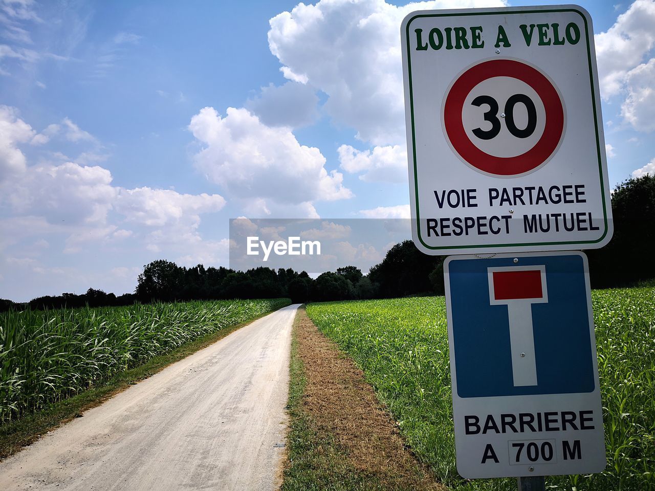 INFORMATION SIGN ON ROAD BY FIELD