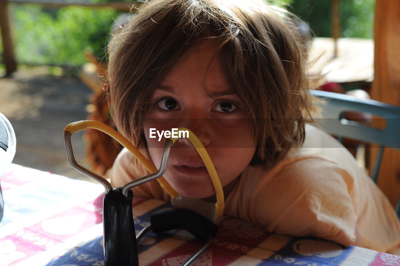 Close-up portrait of girl by table