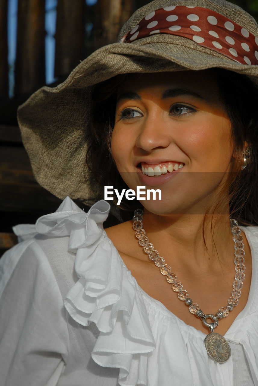 CLOSE-UP PORTRAIT OF A SMILING YOUNG WOMAN WITH HAT