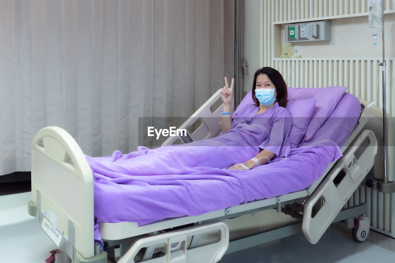 Female patient smiling and showing encouragement in the hospital room. medical health care concept