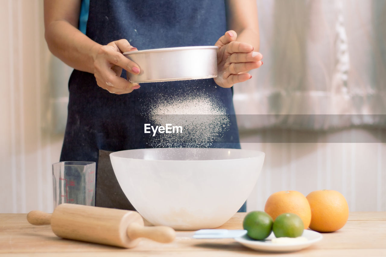 Midsection of woman preparing food in kitchen