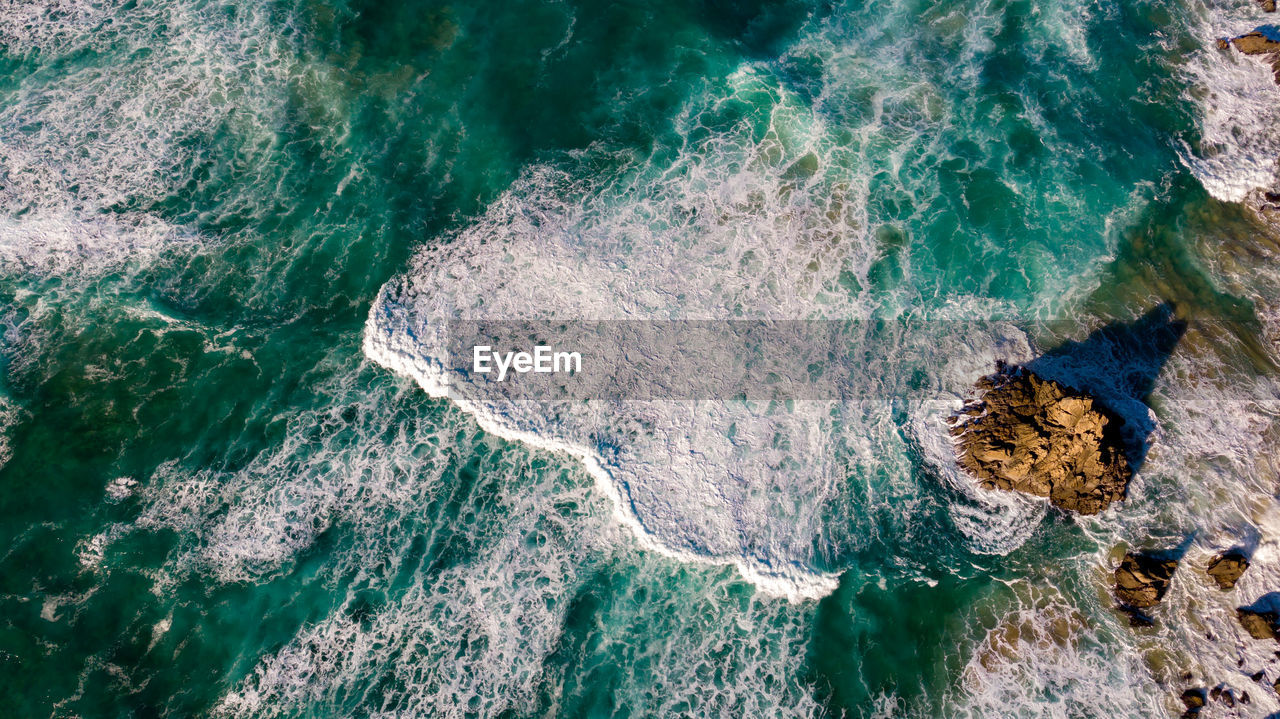 HIGH ANGLE VIEW OF ROCKS ON BEACH