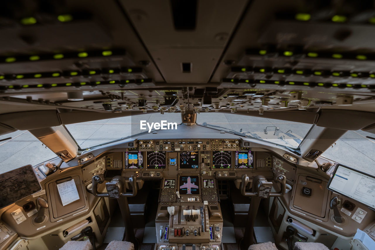 HIGH ANGLE VIEW OF AIRPLANE AT AIRPORT SEEN THROUGH BUS