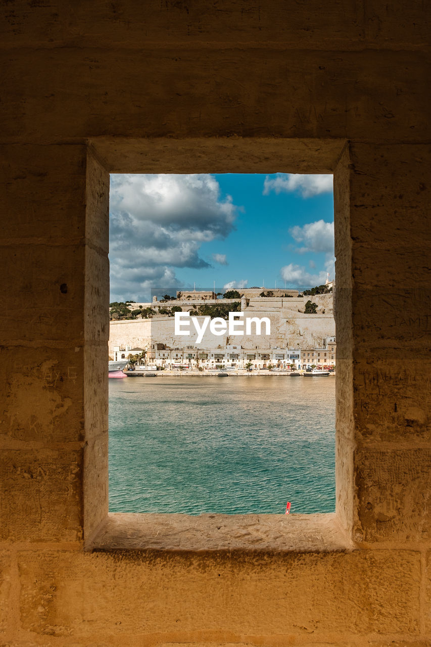 View through the windows of an old watchtower on the skyline of valletta with harbor. 