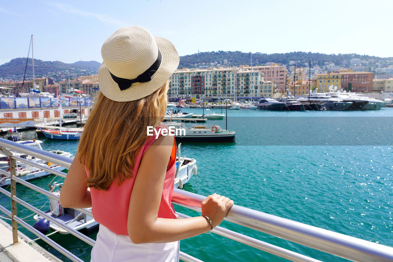 Young woman looks out on the main port of nice also known as lympia port, french riviera.