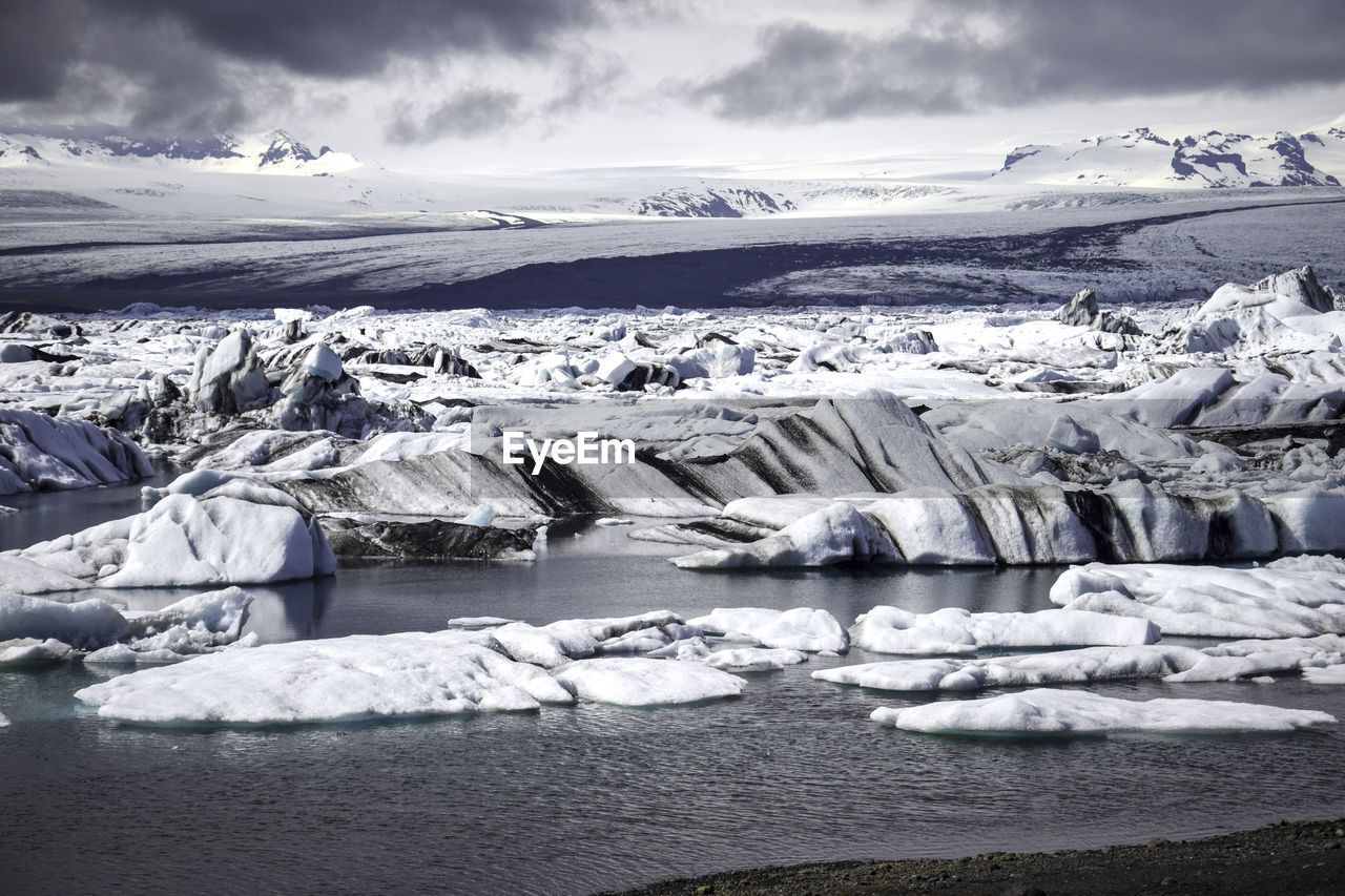 Scenic view of snowcapped mountain against cloudy sky