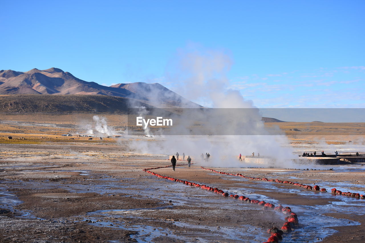 People at hot spring against mountain