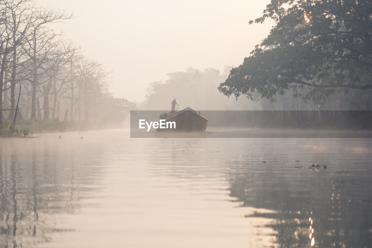 Lonely boat floating on river in haze morning in barisal in bangladesh