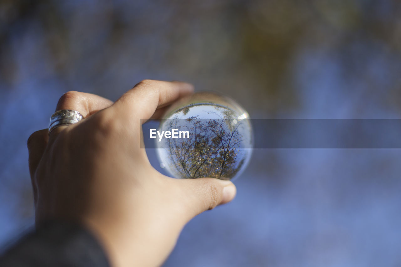 Midsection of person holding a lens ball