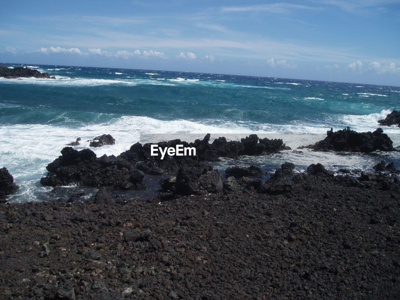 ROCKS ON BEACH AGAINST SKY