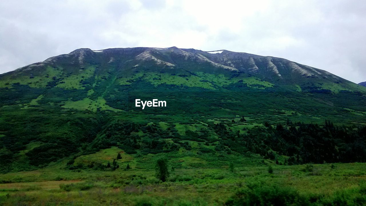 SCENIC VIEW OF MOUNTAINS AGAINST CLOUDY SKY