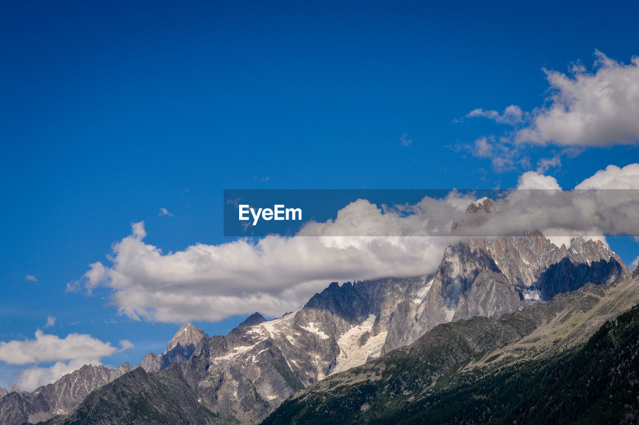 Scenic view of mountains against blue sky