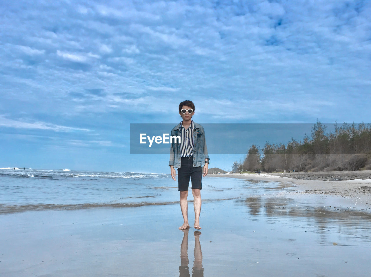 Portrait of young woman standing on beach