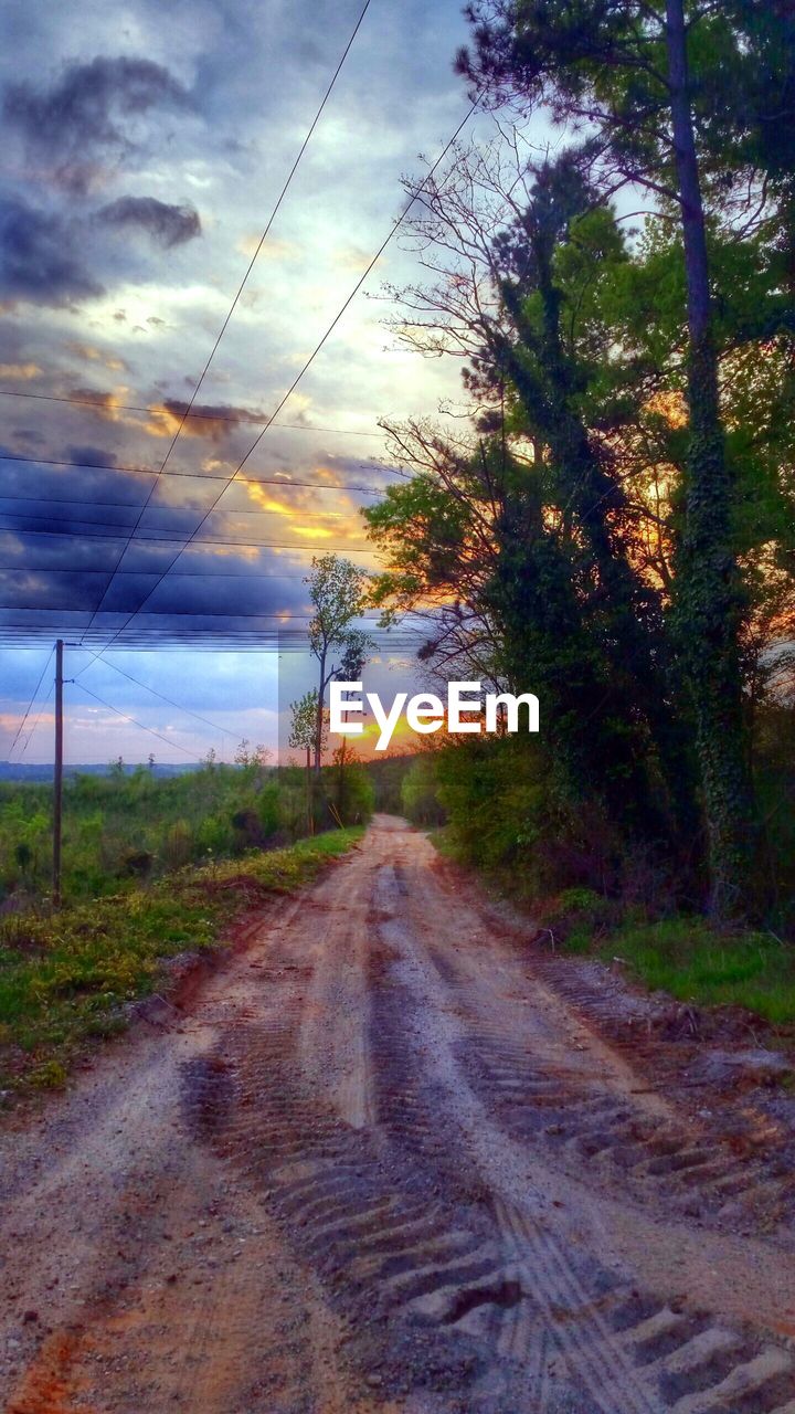 ROAD PASSING THROUGH FIELD AGAINST CLOUDY SKY