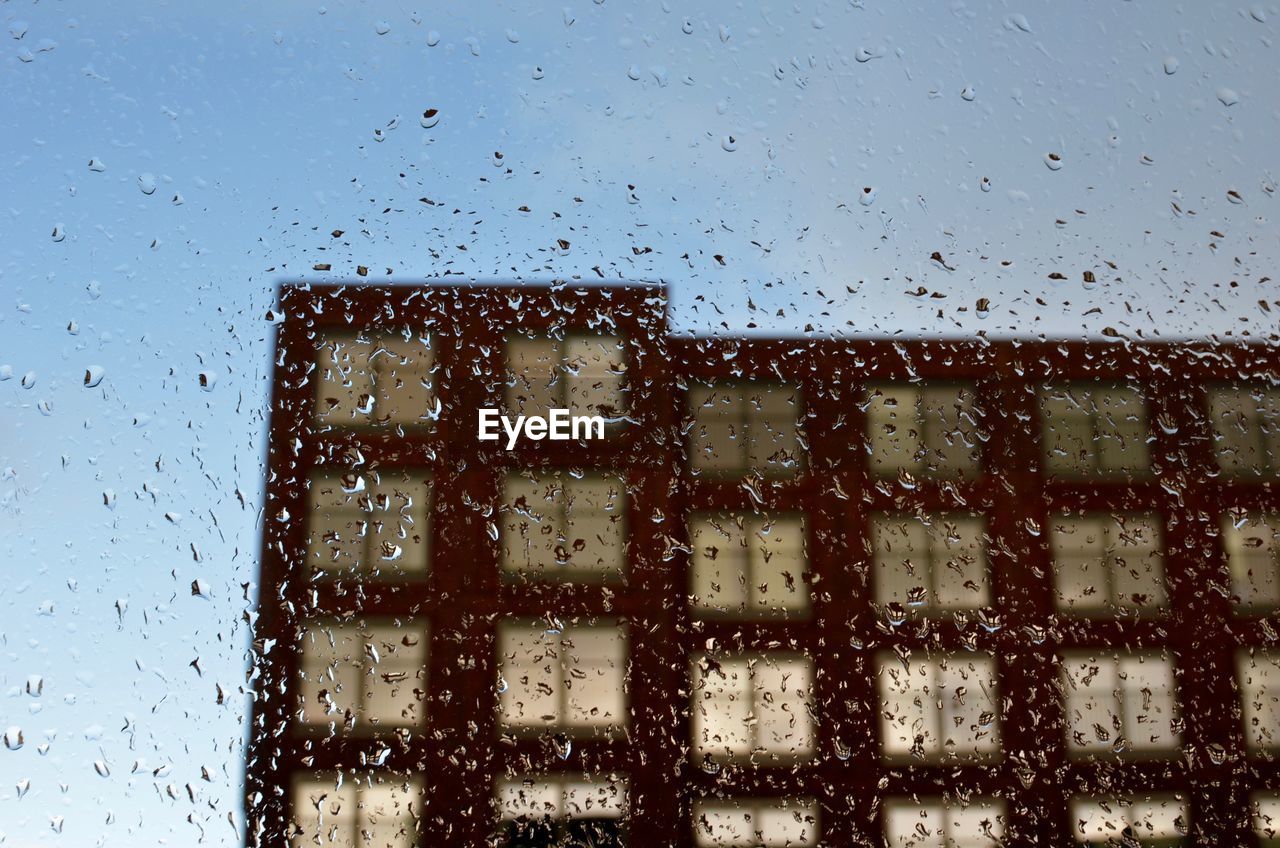 CLOSE-UP OF WET WINDOW AGAINST SKY