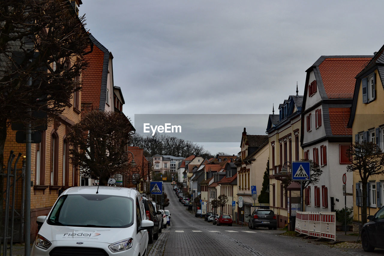 CARS ON STREET AMIDST BUILDINGS IN CITY