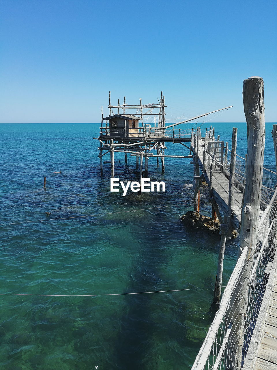 LIFEGUARD HUT ON SEA AGAINST CLEAR BLUE SKY