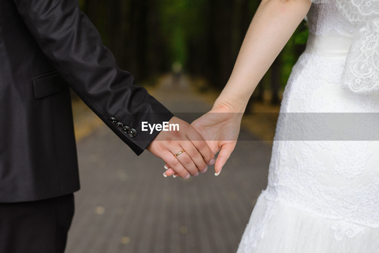 A man holds a woman's hand. hands of the bride and groom with a wedding ring close-up