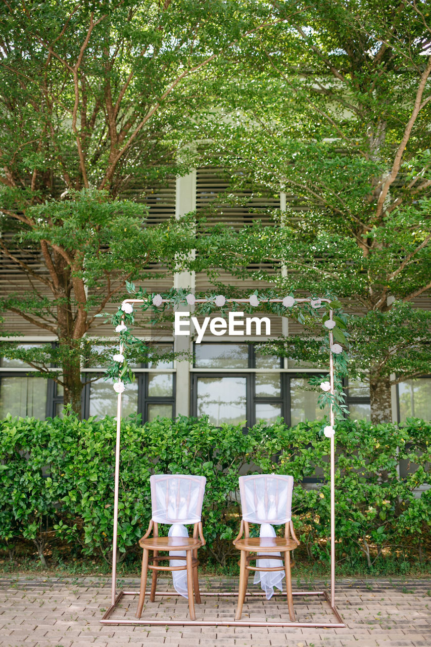 CHAIRS AND TABLES IN YARD AGAINST TREES AND BUILDING