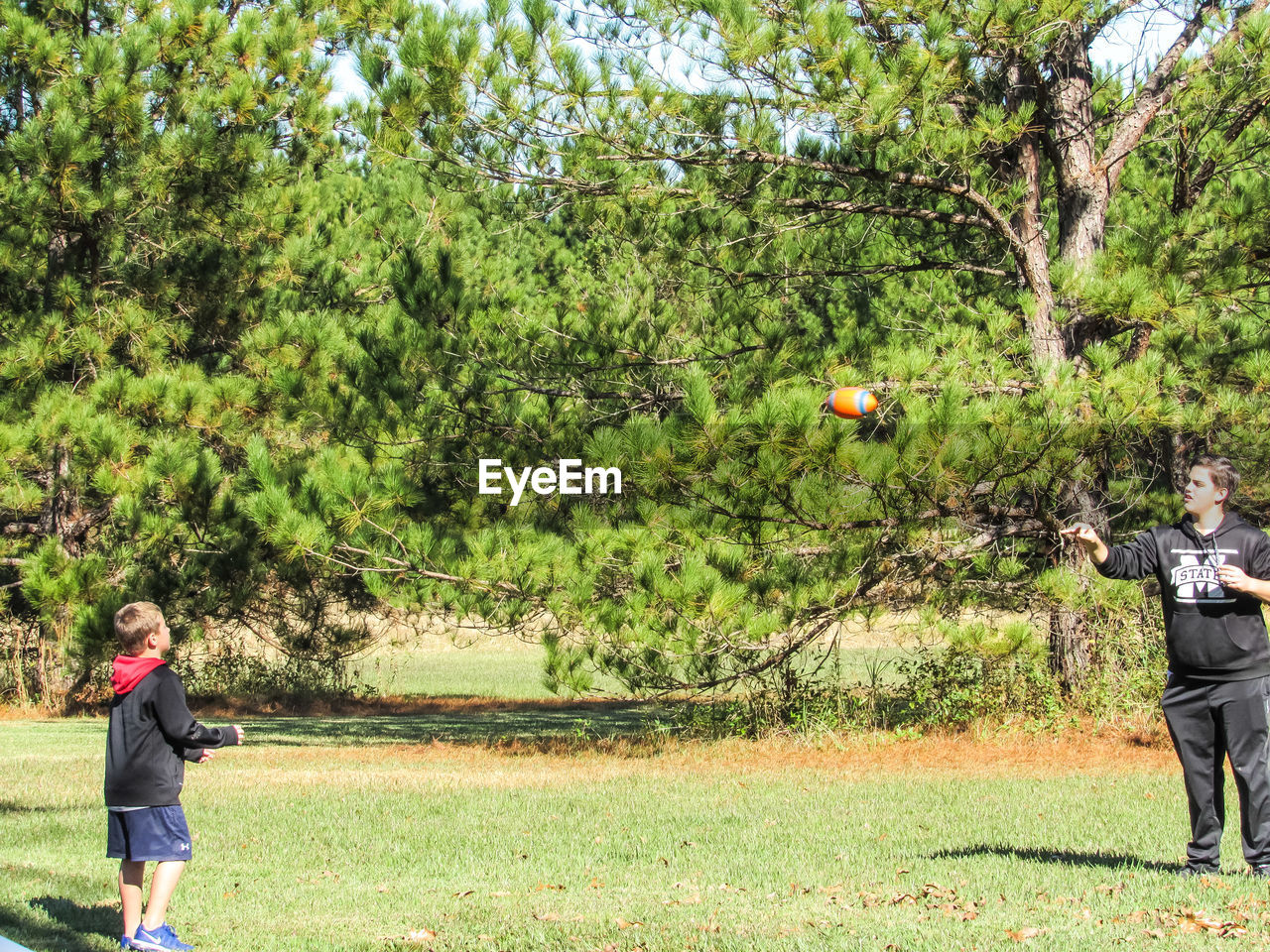 WOMAN STANDING BY TREE