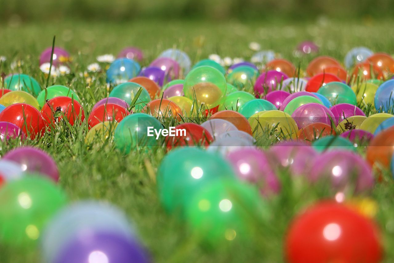 Close-up of colorful balls on grassy field at park during sunny day