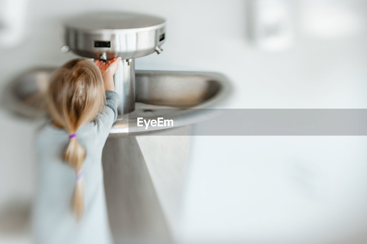 5 years old girl washing her hand in pandemic time