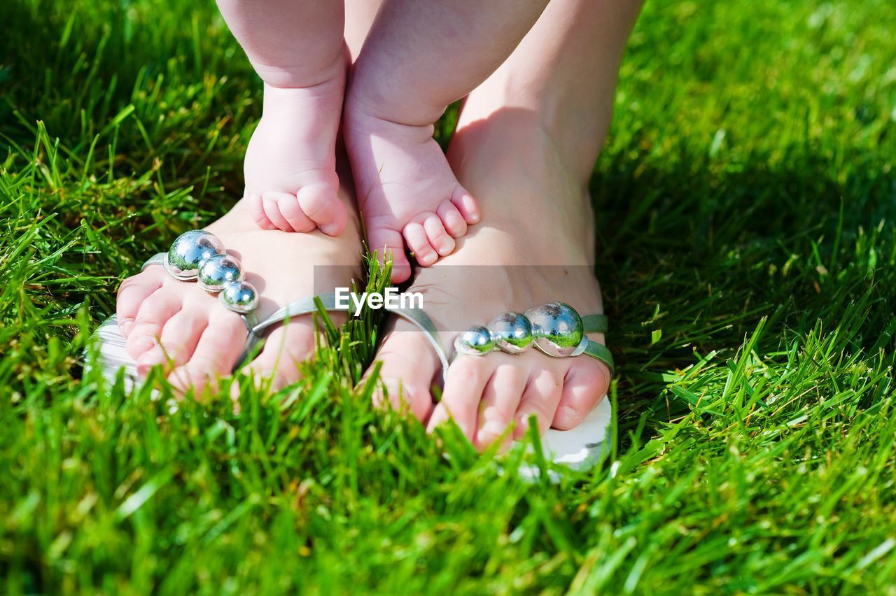 Low section of woman with baby on field