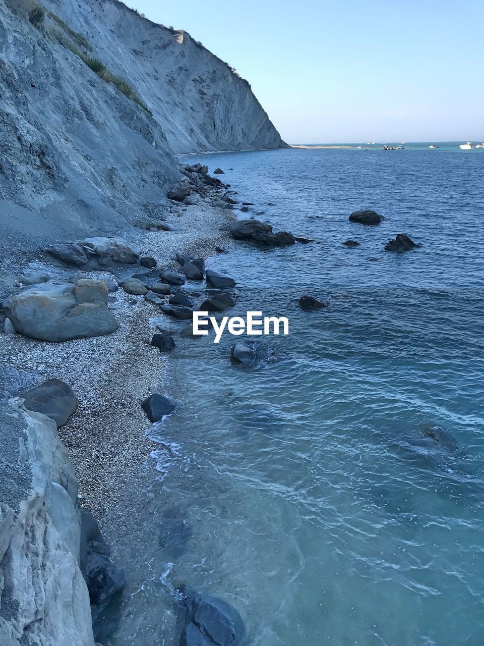 ROCK FORMATIONS IN SEA AGAINST CLEAR SKY