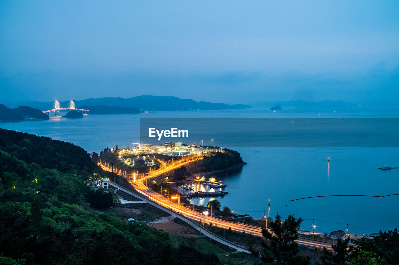 High angle view of city by sea against sky