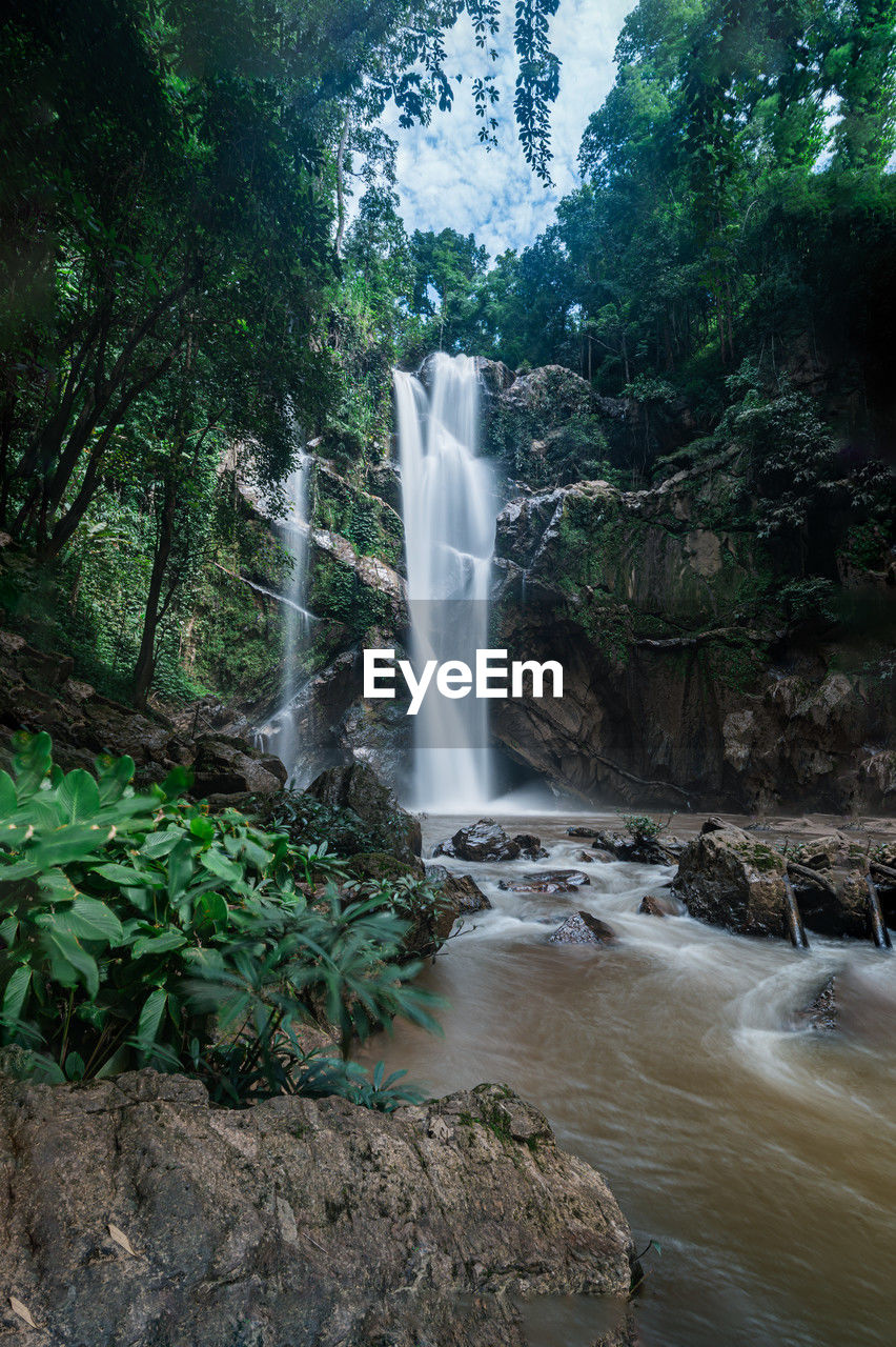 waterfall, water, tree, scenics - nature, beauty in nature, plant, motion, forest, nature, long exposure, environment, water feature, body of water, land, flowing water, rock, blurred motion, jungle, flowing, rainforest, non-urban scene, stream, travel destinations, landscape, tourism, travel, no people, outdoors, power in nature, river, watercourse, splashing, growth, environmental conservation, water resources, green, idyllic, day, rock formation, social issues, vacation, trip