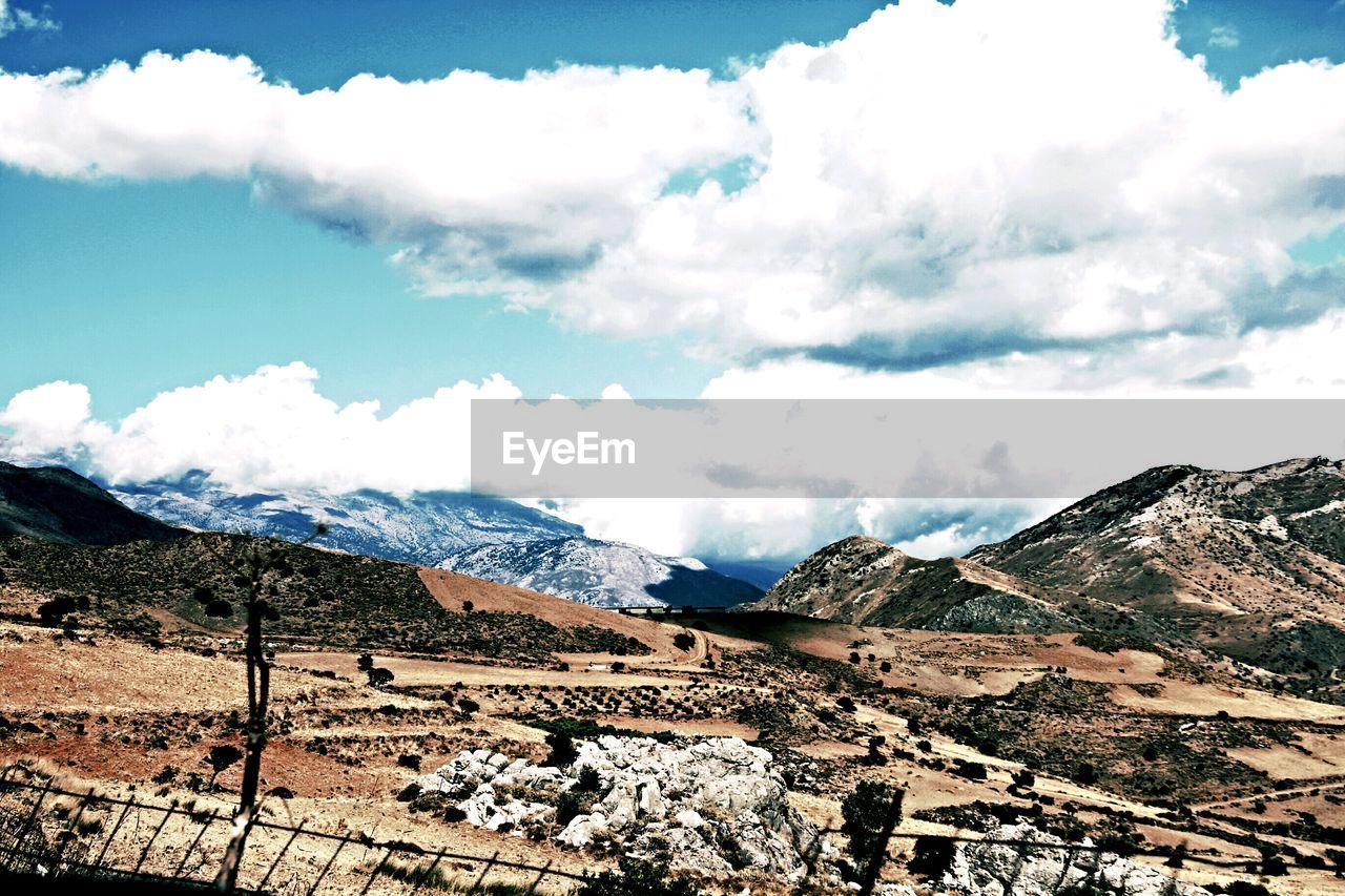 High angle view of countryside landscape against clouds