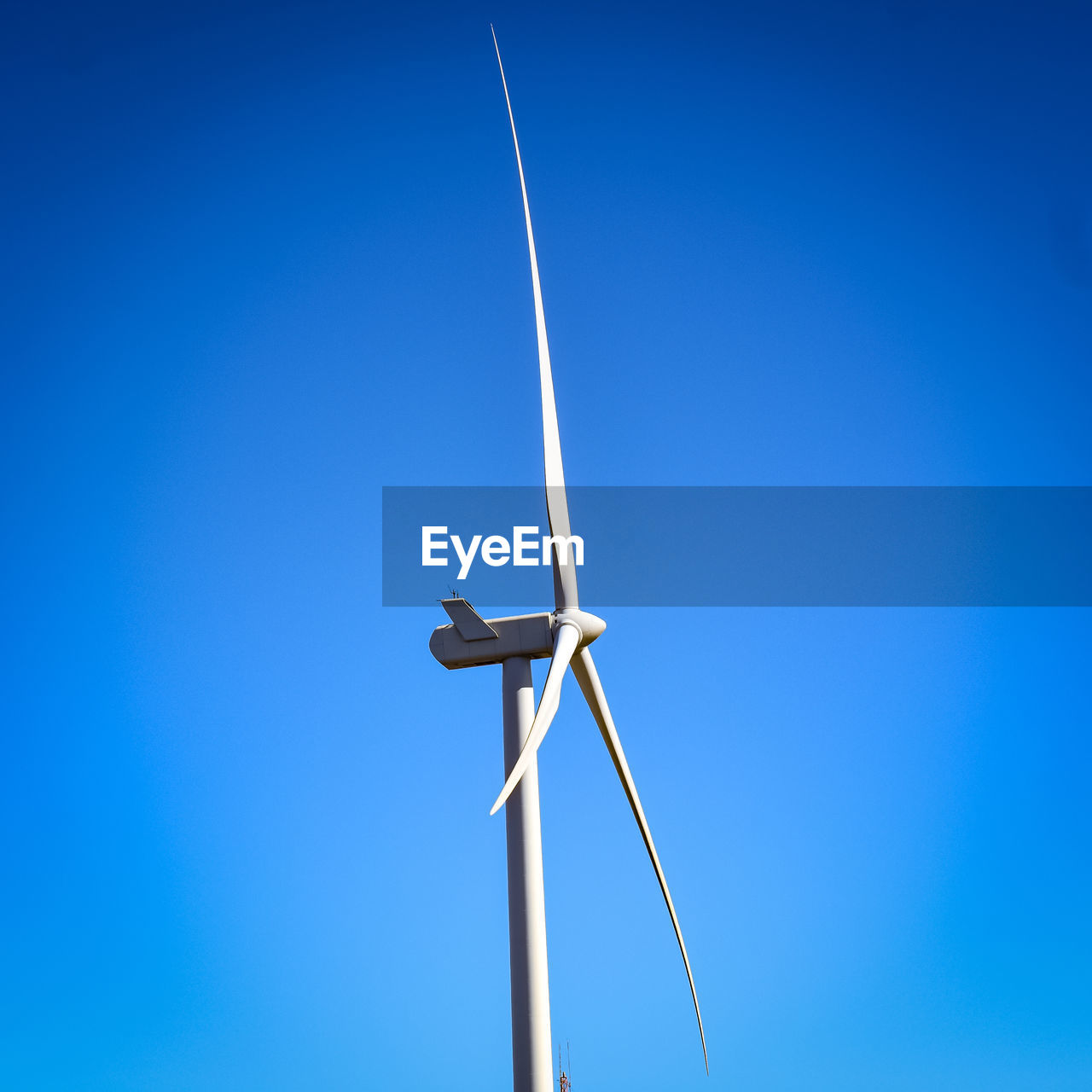 LOW ANGLE VIEW OF WINDMILL AGAINST CLEAR BLUE SKY