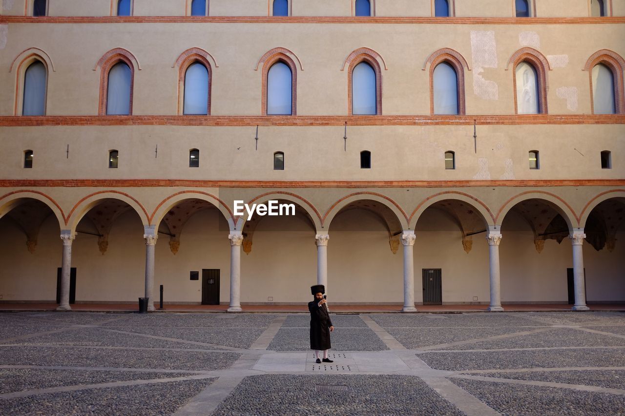 Full length of man taking selfie by mobile phone in historic building