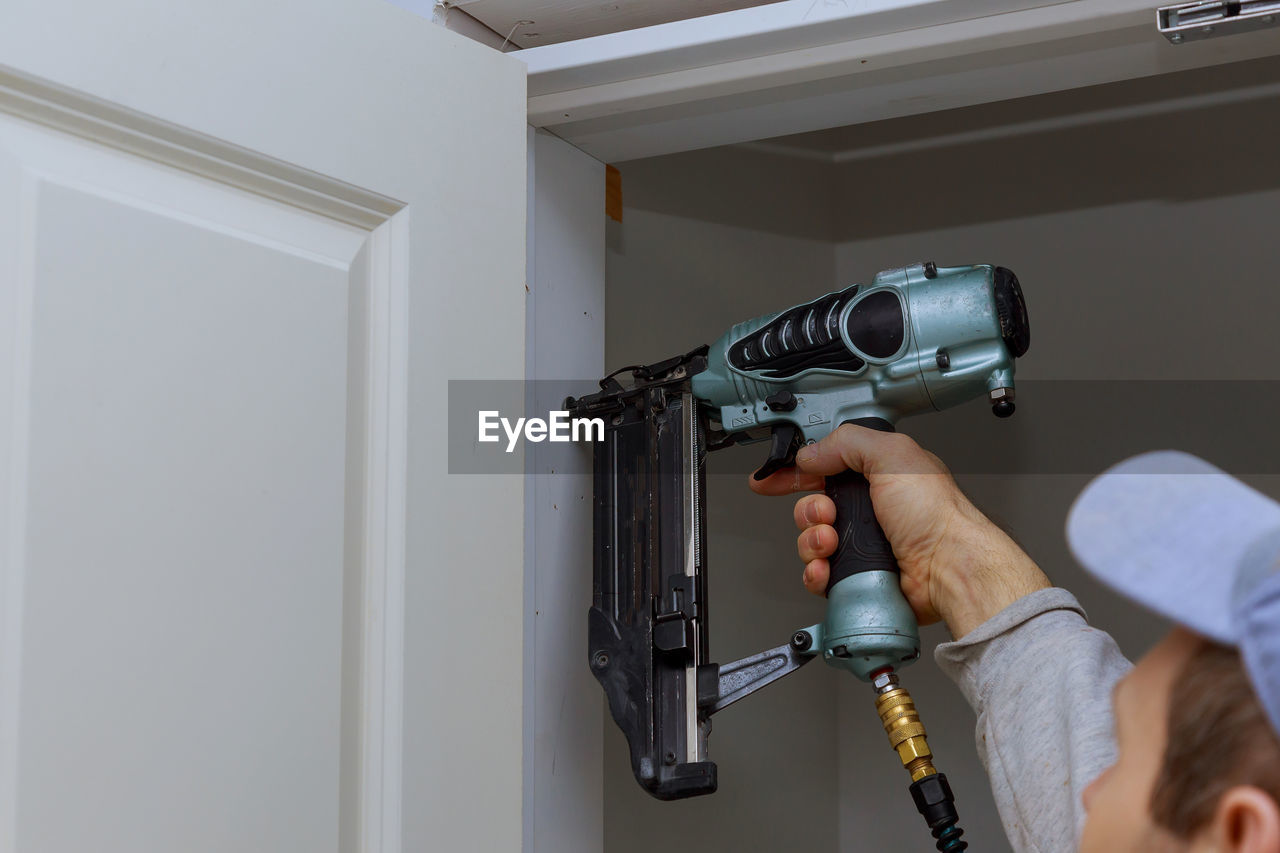 Carpenter using drill at door