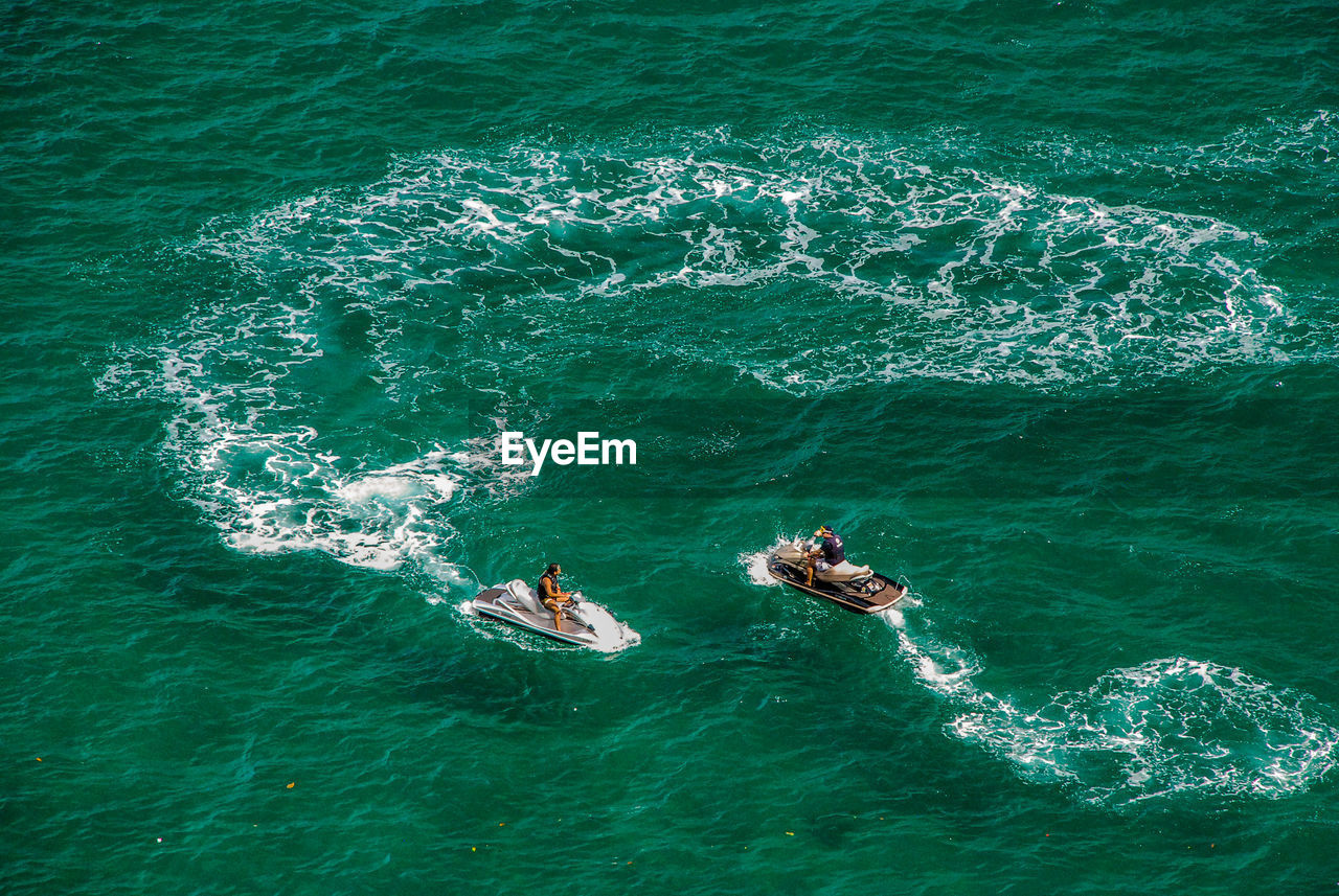 High angle view of men on jet boat in sea