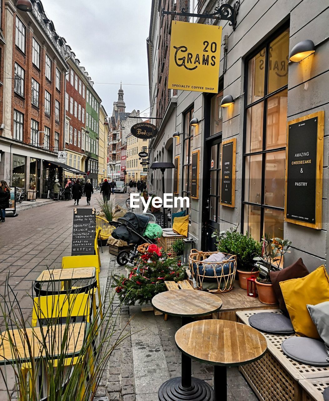 CHAIRS AND TABLES ON STREET AMIDST BUILDINGS