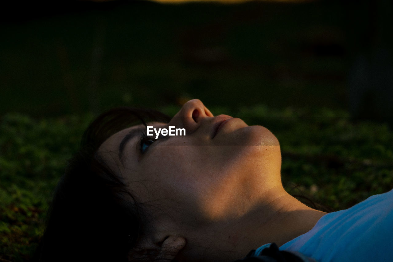 Close-up of young woman lying in park