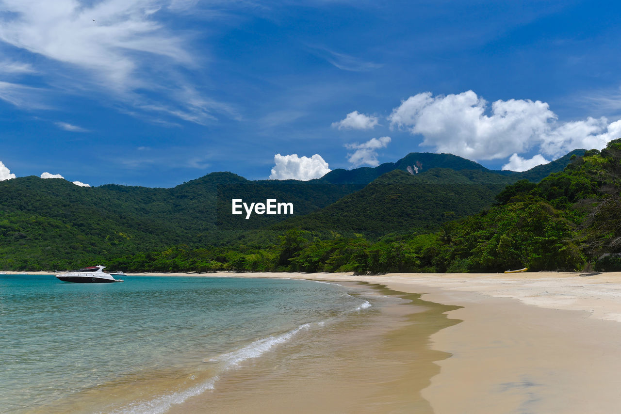 SCENIC VIEW OF SEA AGAINST MOUNTAINS