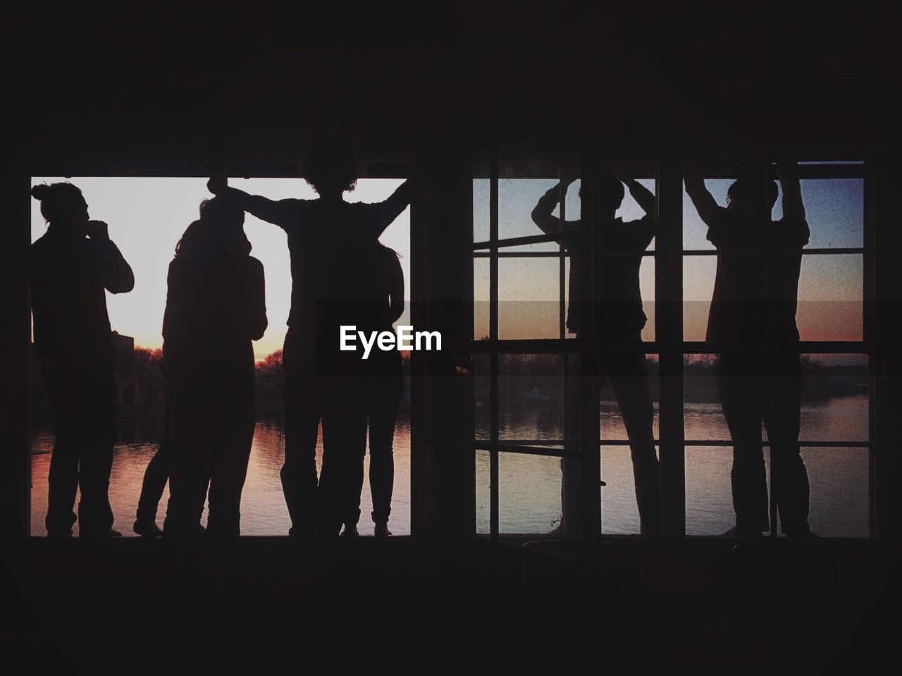 SILHOUETTE OF PEOPLE STANDING IN CORRIDOR OF BUILDING