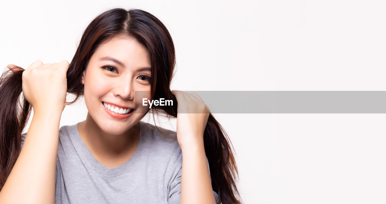 PORTRAIT OF A SMILING YOUNG WOMAN