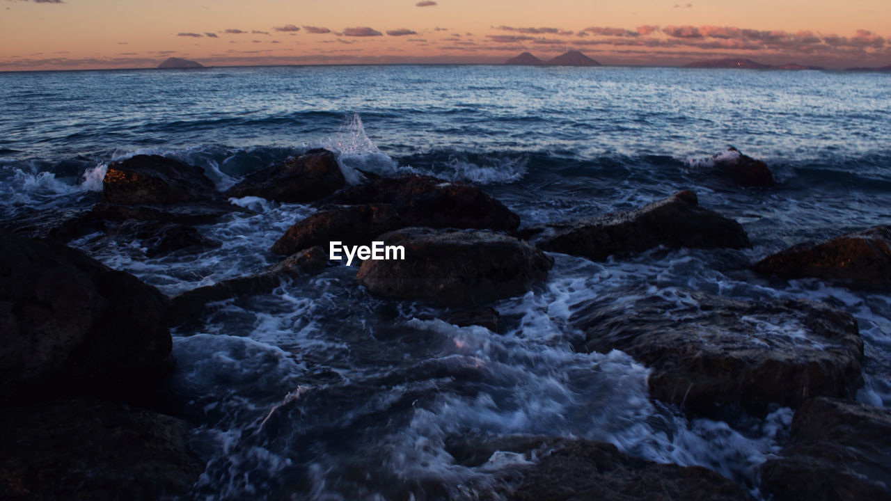 SCENIC VIEW OF ROCKS IN SEA AGAINST SKY