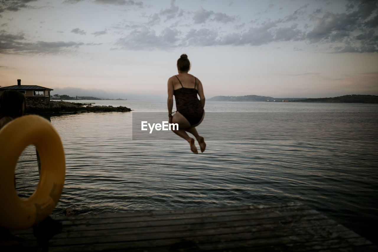 Woman jumping into water
