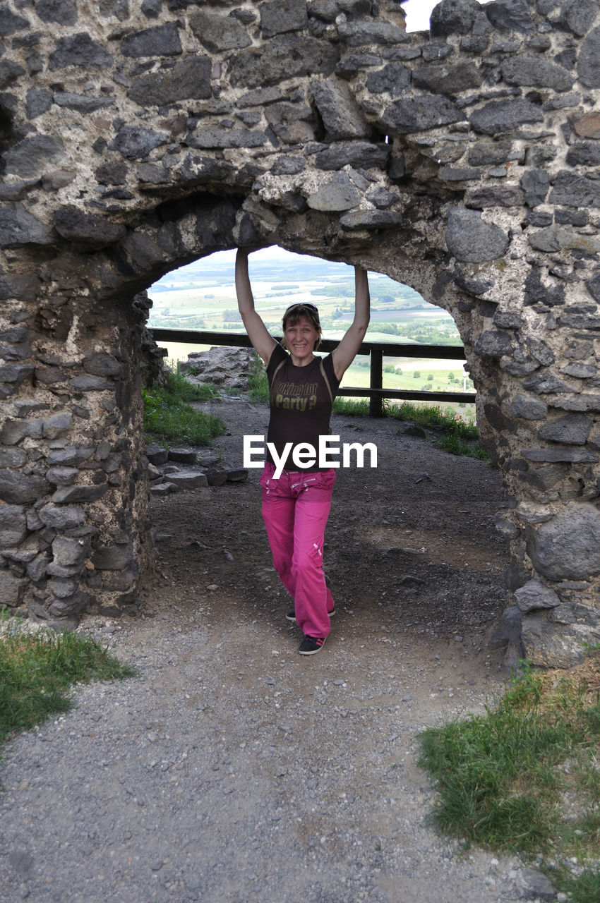 Portrait of smiling woman standing under archway 